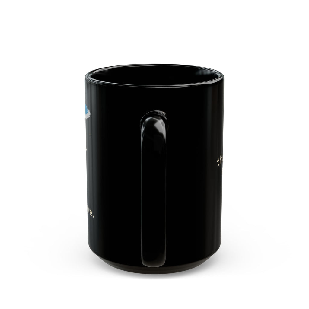 Alien Sitting on Rock Black Mug — “free to believe.” 11oz & 15oz