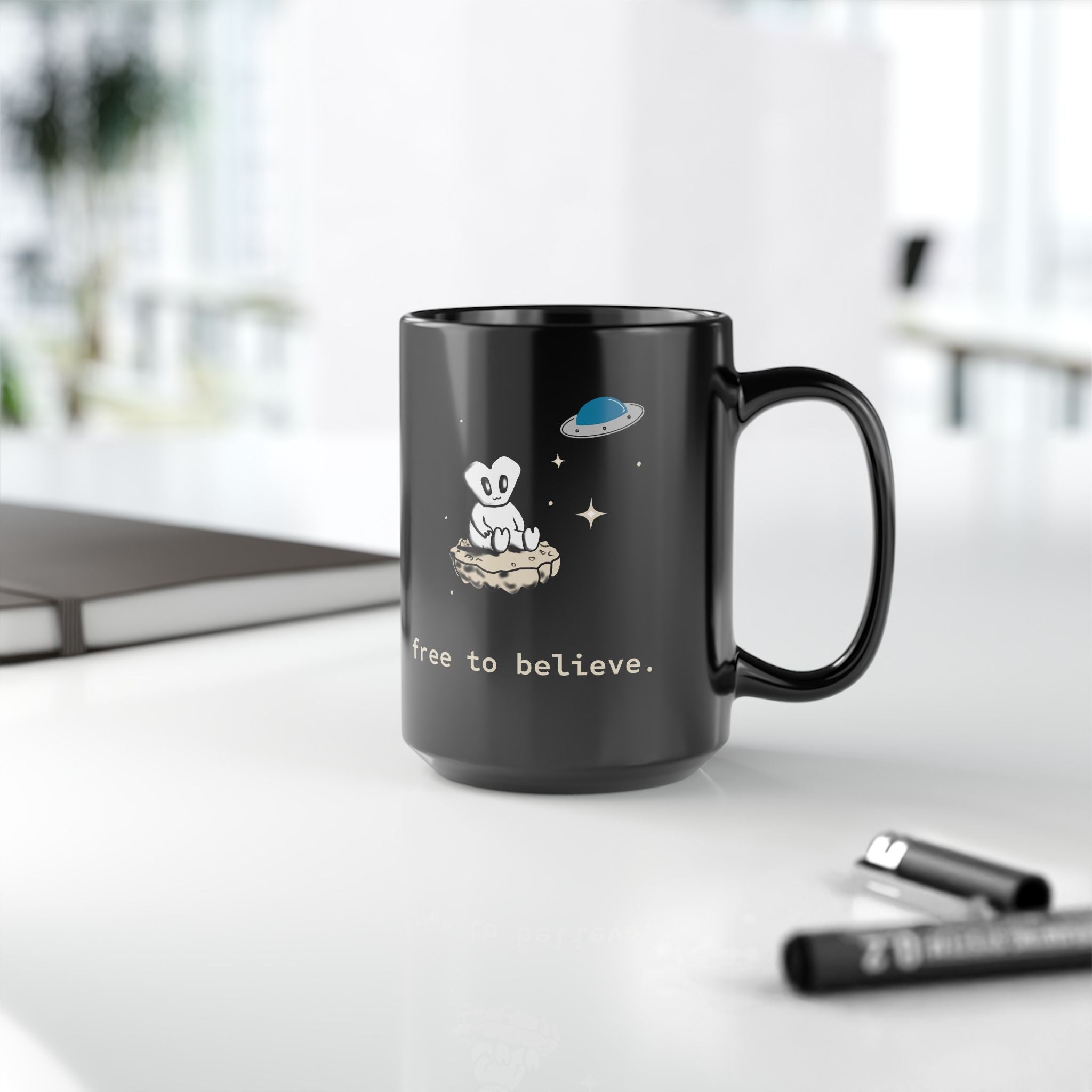 Alien Sitting on Rock Black Mug — “free to believe.” 11oz & 15oz
