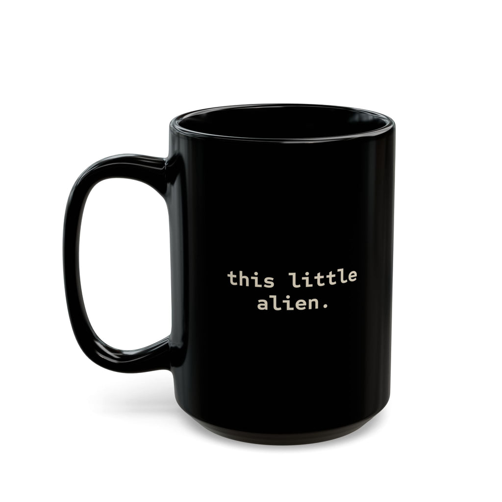 Alien Sitting on Rock Black Mug — “free to believe.” 11oz & 15oz